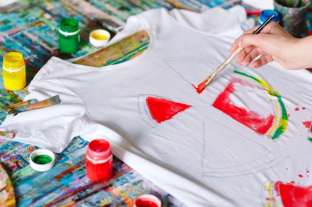 Woman draws watermelon slices on a white T-shirt