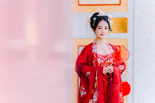 중국의 신년 초상화: 전통 의상을 입은 여성, 밝은 빨간 옷을 입은 아름다운 젊은 여성, 중국 여왕의 왕관.