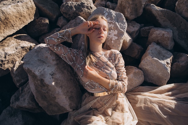 Woman in a dress lying on rocky stones