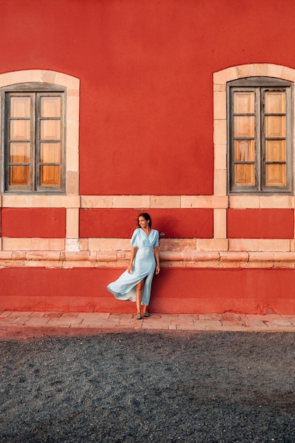 Woman in dress near red building