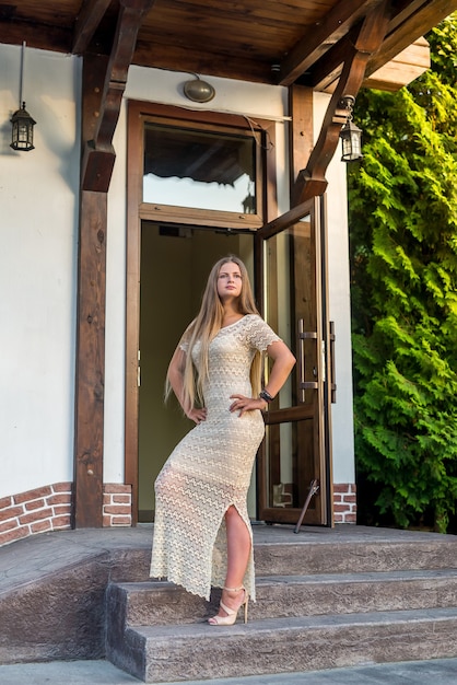 Woman in dress posing while standing on stairs