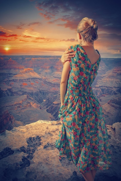 Woman in dress stands in the Grand Canyon