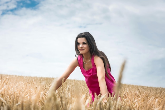 Woman in dress stands in wheat field Beautiful at nature