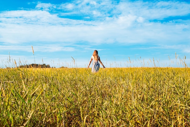 Woman in a dress walking along the field