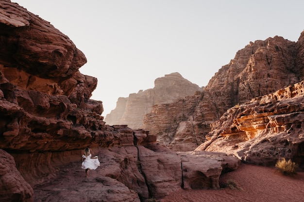 Woman in dress walking on landscape against sky