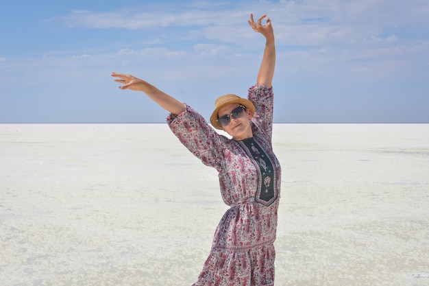 Woman in dress on white salt lake, portrait of woman on salt lake