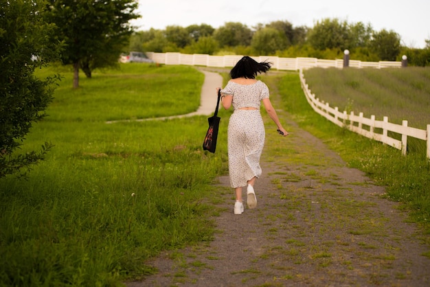 A woman in a dress with a bag that says " she's a lady ".