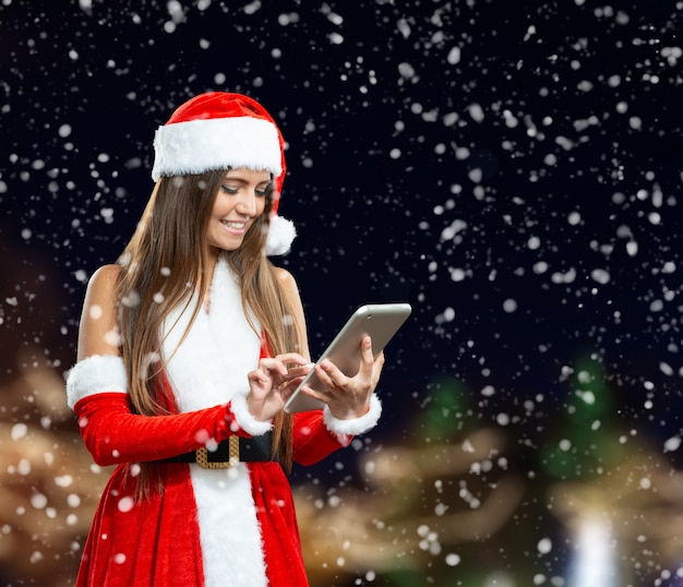 Woman dressed as Santa Claus using a digital tablet