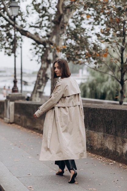 Woman dressed in coat walking on the famous square with view on the eiffel tower