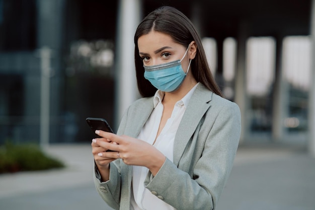 Una donna vestita con camicia e giacca con maschera protettiva sul viso