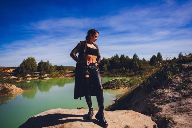 Woman dressed in a steampunk suit against the background of a dirty lake