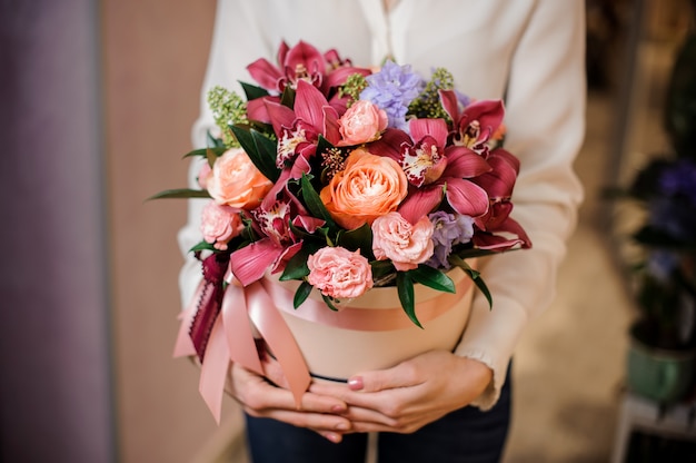 Woman dressed in a white blouse with a box of flowers