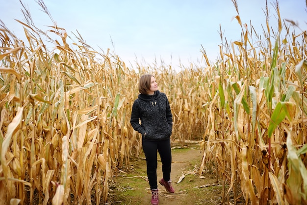 woman among the dried corn stalks in a corn maze