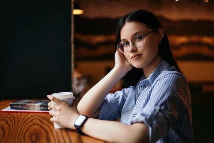 女性はカフェでコーヒーを飲む