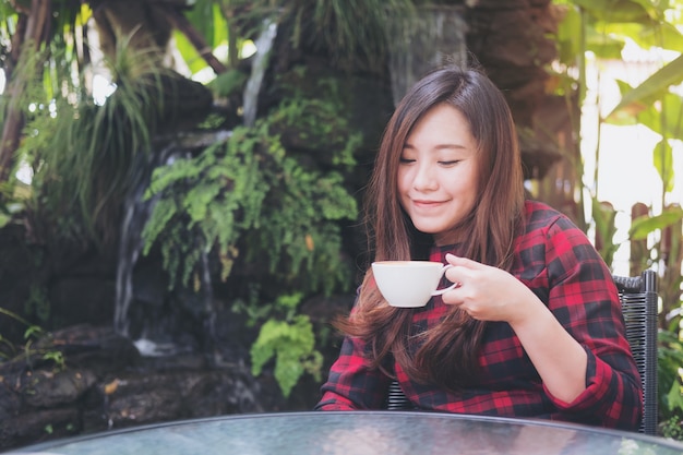 屋外で女性飲み物のコーヒーカップ