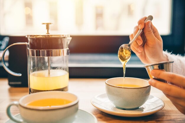 女性はカフェでホットオレンジティーを飲みます