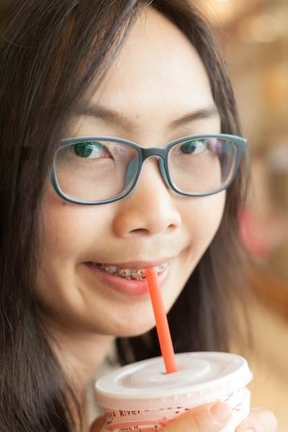 女性は氷のミルクを飲む。