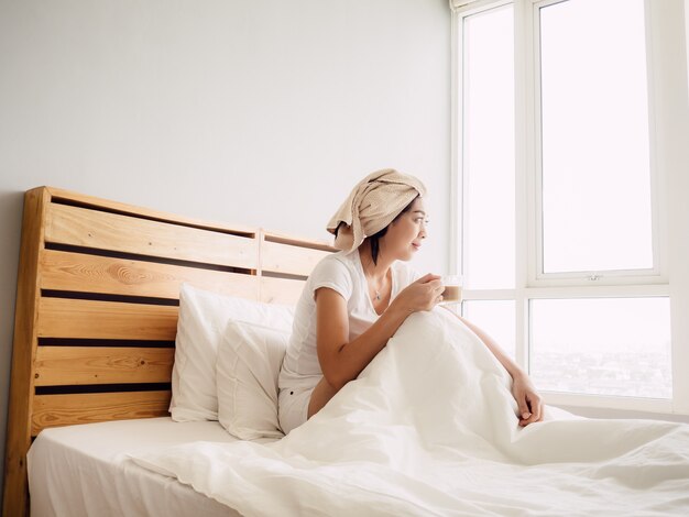 Woman drink morning coffee after shower.