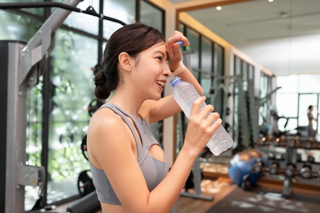 Woman drink water from plastic bottle after workout