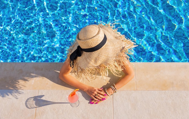 Woman drinking cocktail by the pool view from above