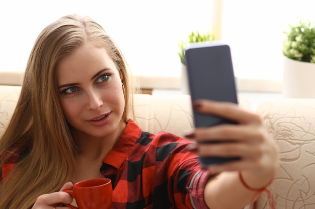 Woman drinking coffe and look at laptop