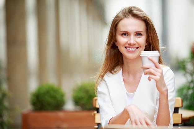 写真 ストリートカフェでコーヒーを飲む女性