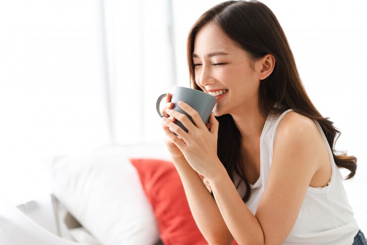 寝室でコーヒーを飲む女性