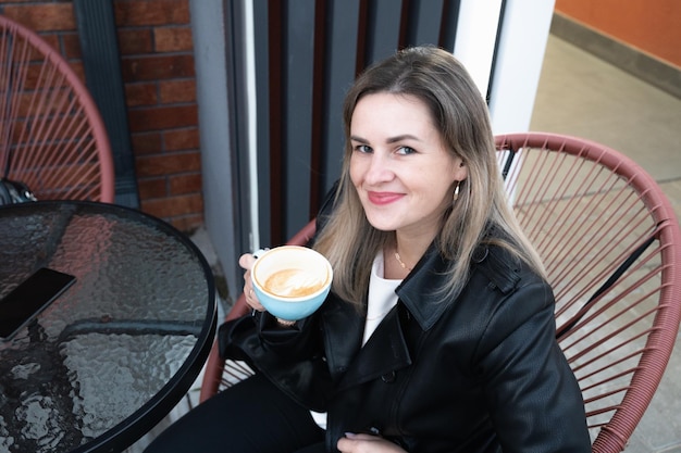 Photo woman drinking coffee in a cafe outdoors