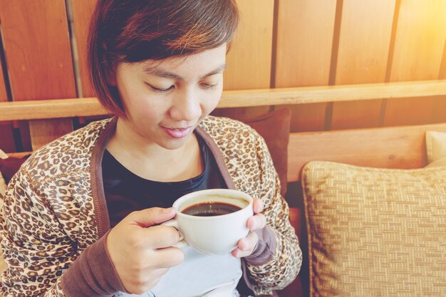 カフェで女性のコーヒーを飲む