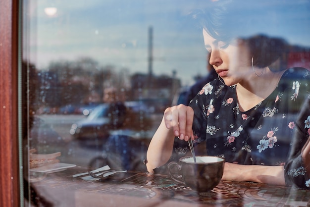 Женщина пьет кофе в кафе