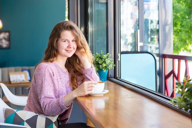 コーヒーショップカフェでコーヒーを飲む女性