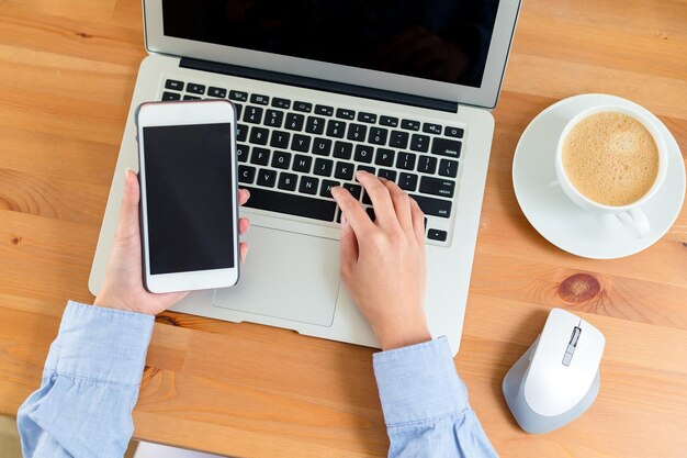 Woman drinking coffee and holding her smartphone