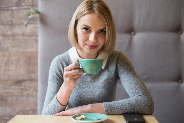 Woman drinking coffee in the morning at restaurant Soft focus on the eyes Sellphone on table