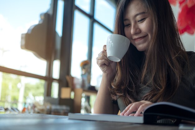 Woman drinking coffee and reading a book 