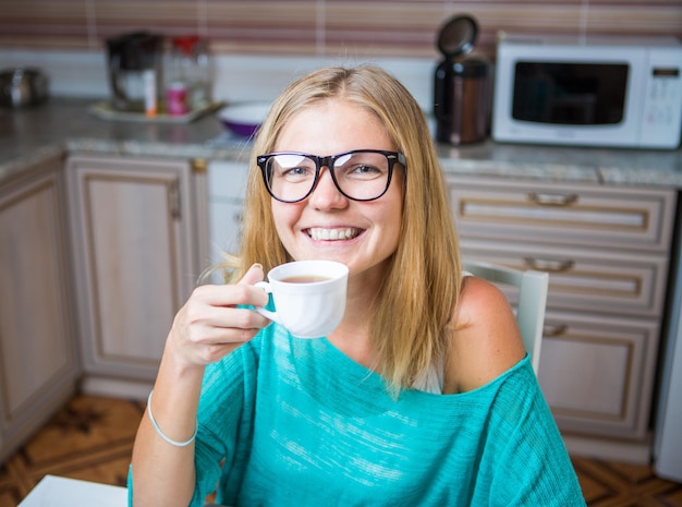 コーヒーを飲みながら微笑む女性