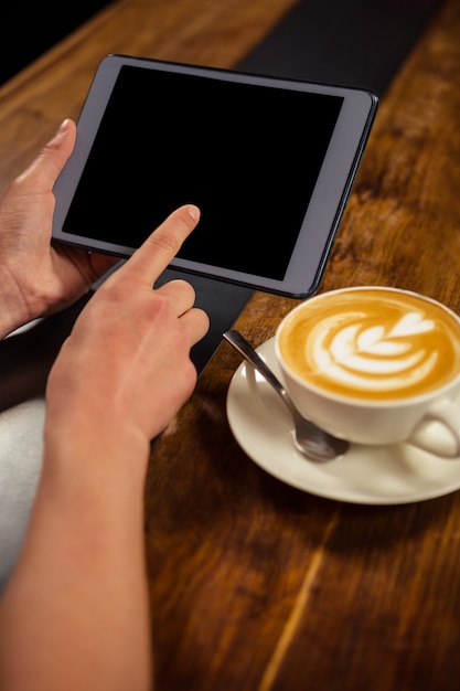 Woman drinking coffee and using tablet