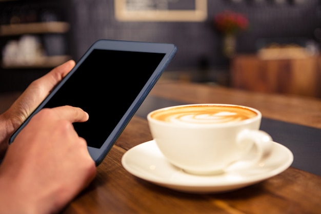 Woman drinking coffee and using tablet