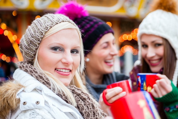 ドイツのクリスマスマーケットにエッグノッグを飲む女性