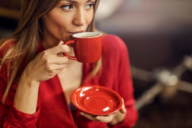 コーヒー工場で淹れたてのコーヒーを飲む女性