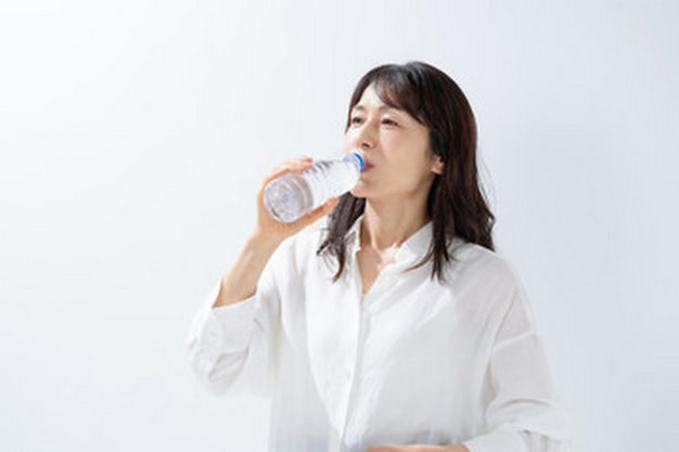 a woman drinking from a bottle of water