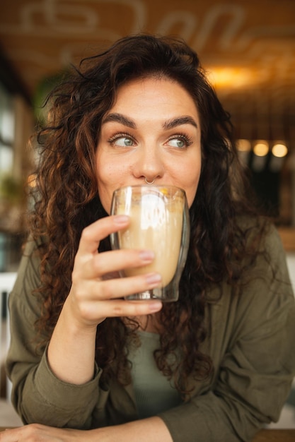 woman drinking a glass of coffee in a cafe