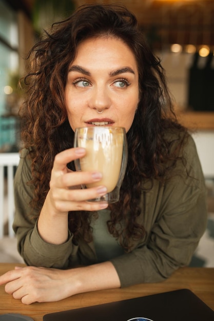 A woman drinking a glass of coffee.