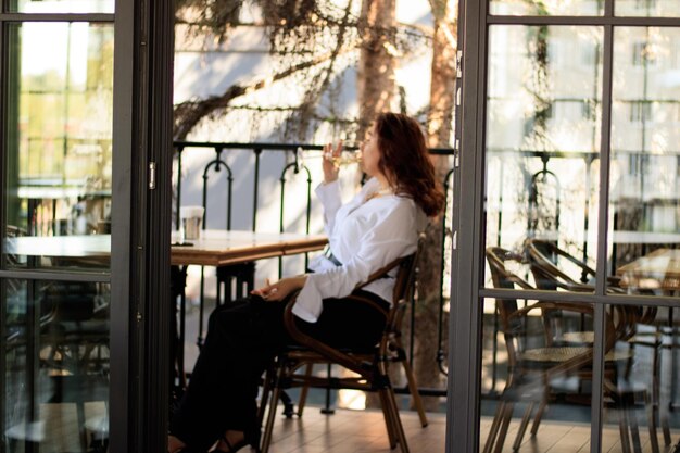 Photo woman drinking a glass of red wine on the terrace