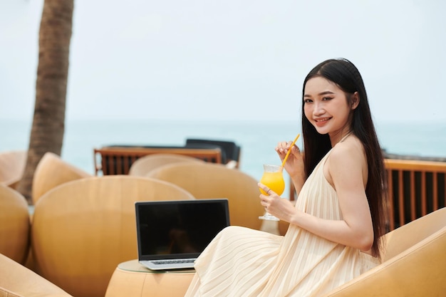 Photo woman drinking juice before online meeting
