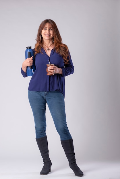 woman drinking mate holding a termo