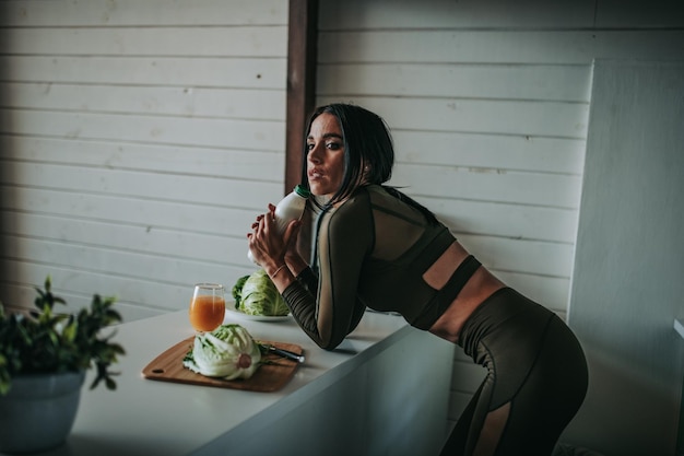 Foto donna che beve latte in cucina a casa