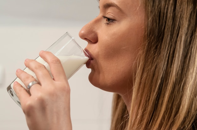 Женщина пьет молоко. женщина, пьющая из стакана соевого молока