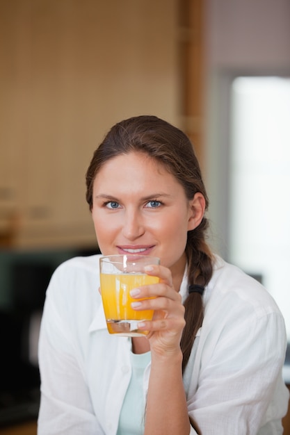 オレンジジュースを飲む女性