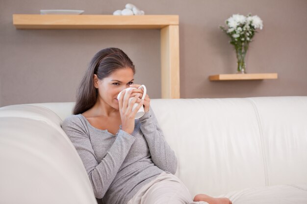 ソファーでコーヒーを飲む女性