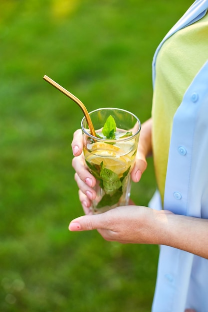 Woman drinking summer citrus lemonade with reusable metal straws party